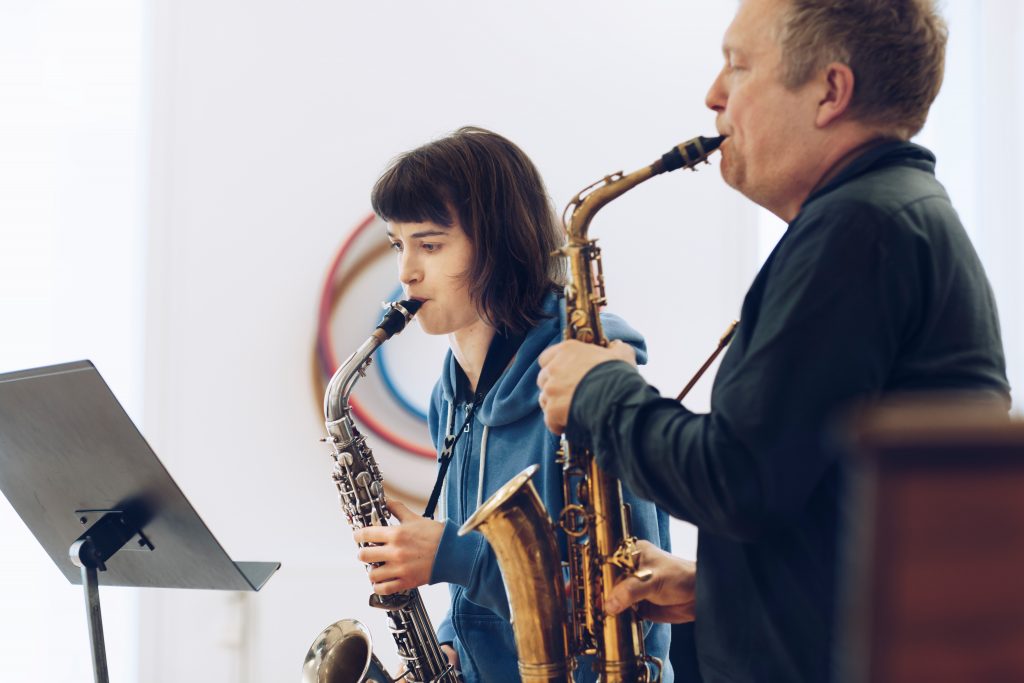 Teacher and student with saxophones in class